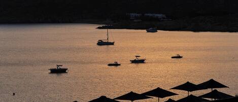 A marina with several boats, umbrellas, and a pool area.
