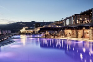 Ein Poolbereich mit Bar und Sitzgelegenheiten mit Blick auf eine Berglandschaft.