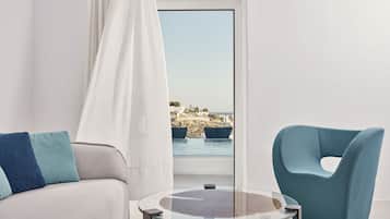 A modern room with a sofa, a blue armchair, and a glass table.