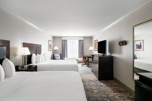A hotel room with two beds, a desk, a television, and a large mirror. - La Quinta Inn & Suites by Wyndham Moab (Moab)