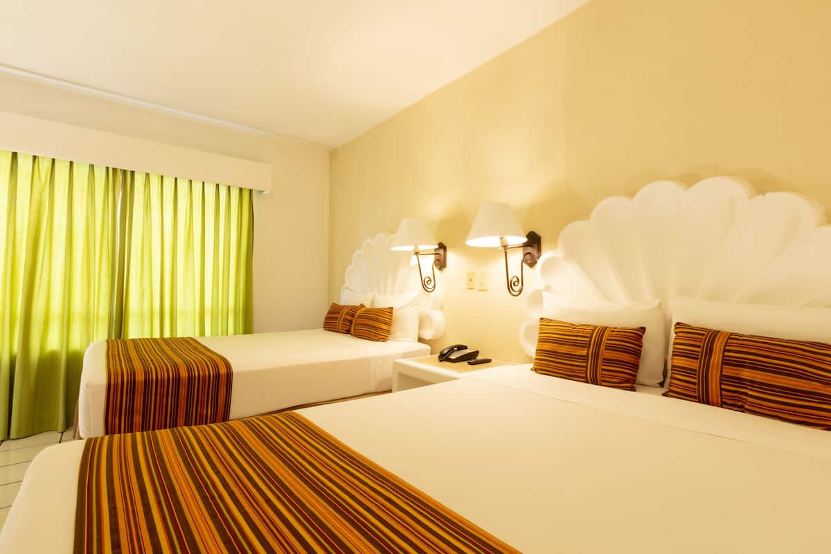 Habitación de hotel con dos camas, cortinas verdes, apliques de pared y cubrecamas a rayas.