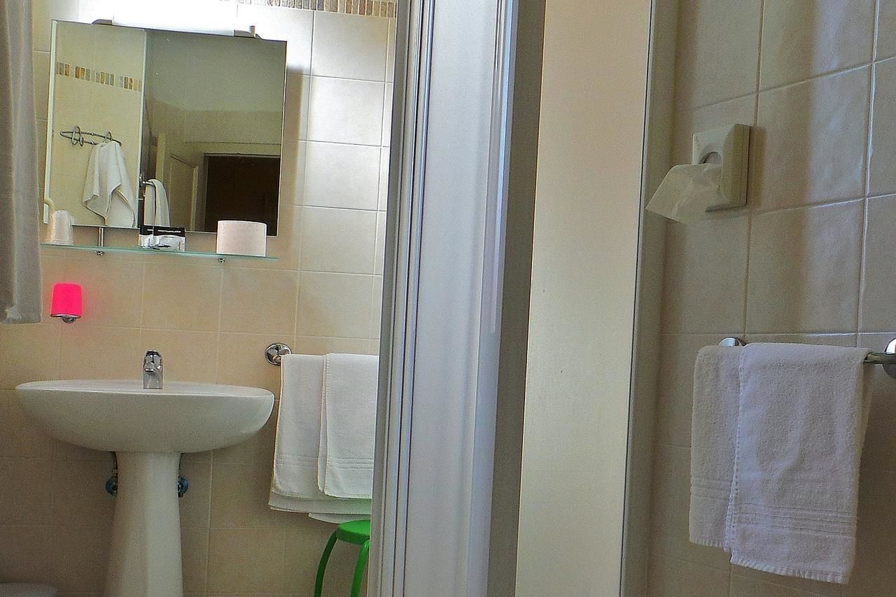 Une salle de bain équipée d’un lavabo, d’un miroir et d’un porte-serviettes.