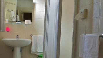 Une salle de bain équipée d’un lavabo, d’un miroir et d’un porte-serviettes.