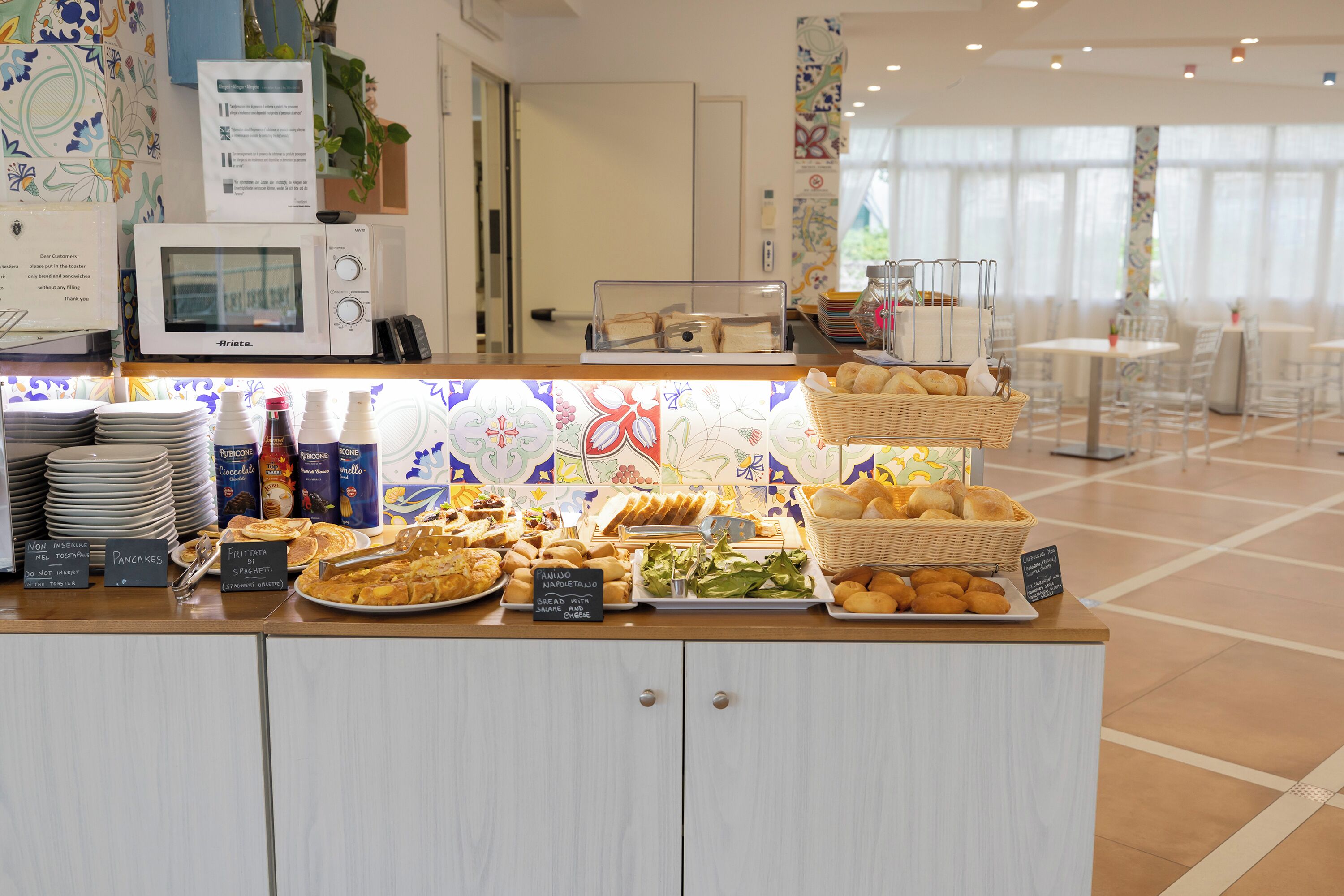 A buffet counter with various food items, a microwave, and a sign indicating a market area.