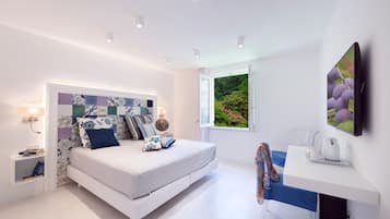 Ein modernes Schlafzimmer mit Bett, Nachttisch und Fenster mit Blick ins Grüne.
