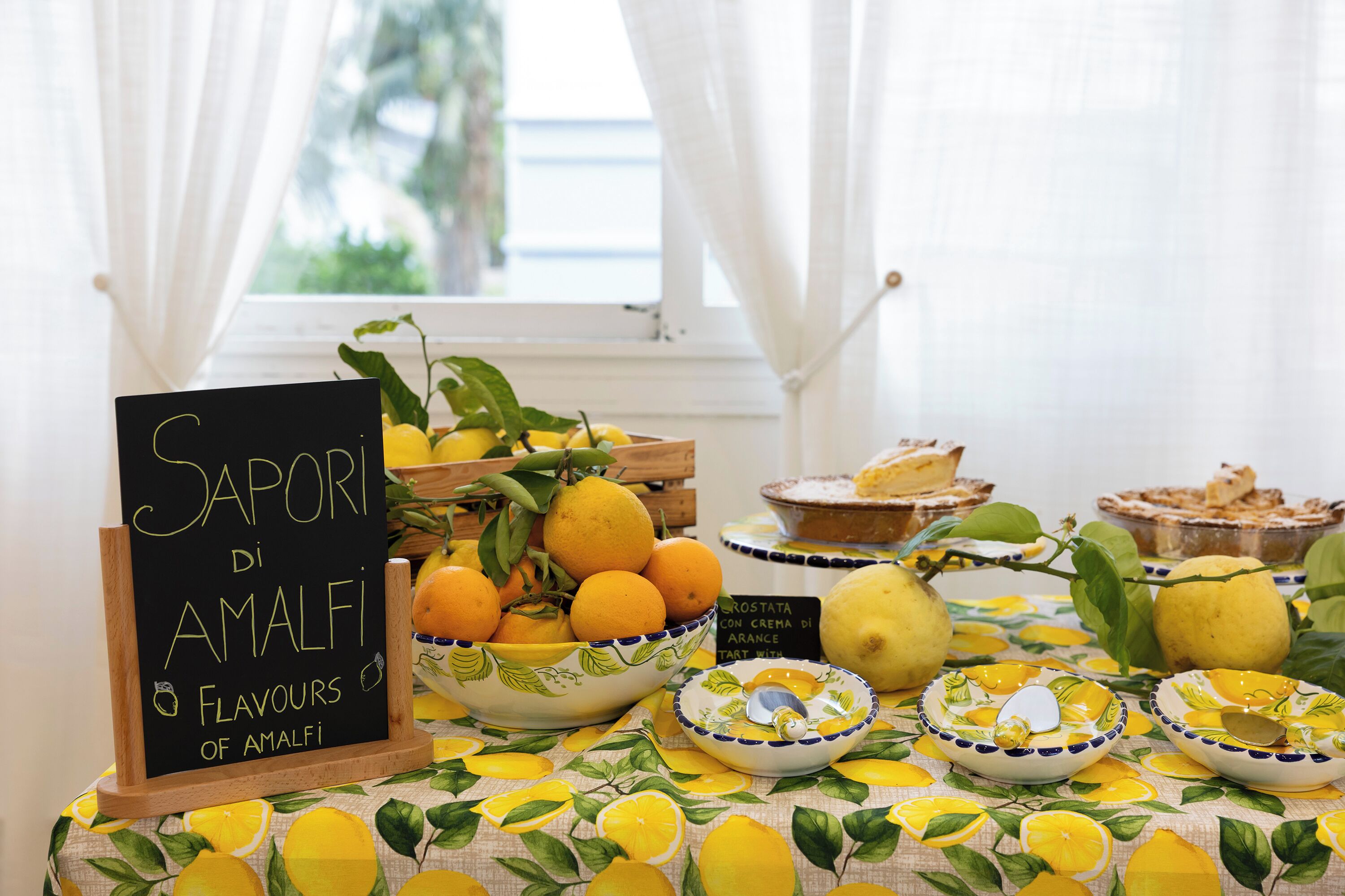 Uma mesa com frutas cítricas, tigelas e um quadro negro.