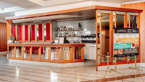 Un ristorante con un bancone, una lavagna dei menù e l'area cucina.