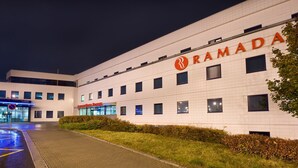 Een modern gebouw, met de naam "RAMADA" duidelijk zichtbaar.