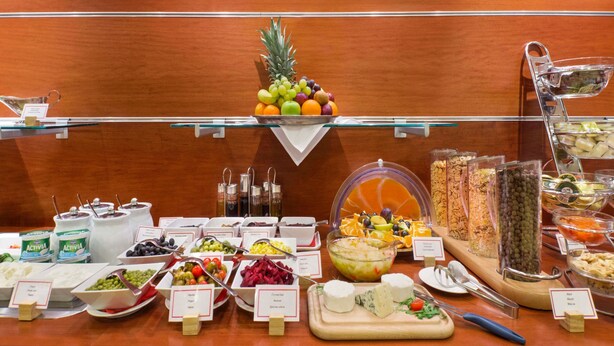 Een buffet met diverse etenswaren, zoals fruit, kazen en salades.