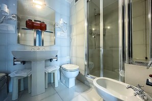 Un bagno moderno con un lavandino capiente, il water e una zona doccia.
