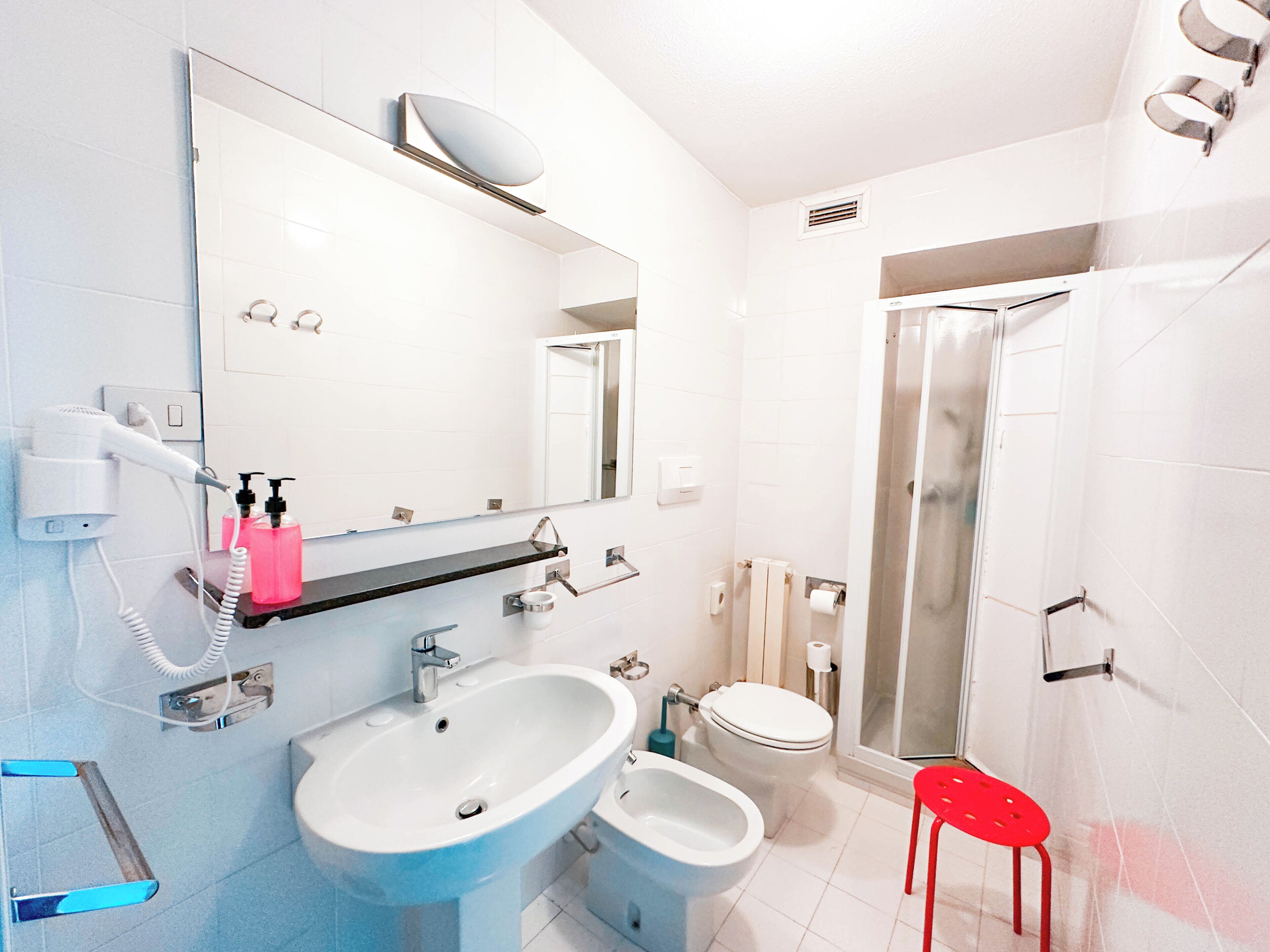 Une salle de bain équipée d’un lavabo, d’un bidet, de toilettes et d’une douche.