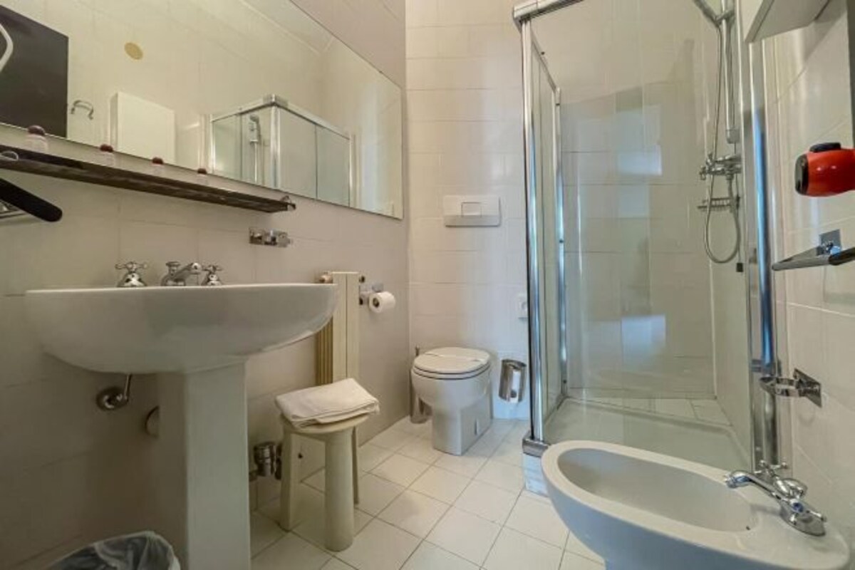 A bathroom with a sink, toilet, and shower area.