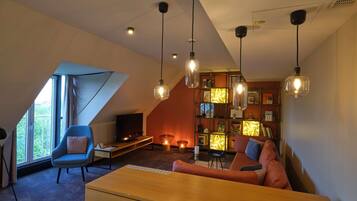 Una sala de estar moderna con un sofá, una silla, un televisor y una estantería.