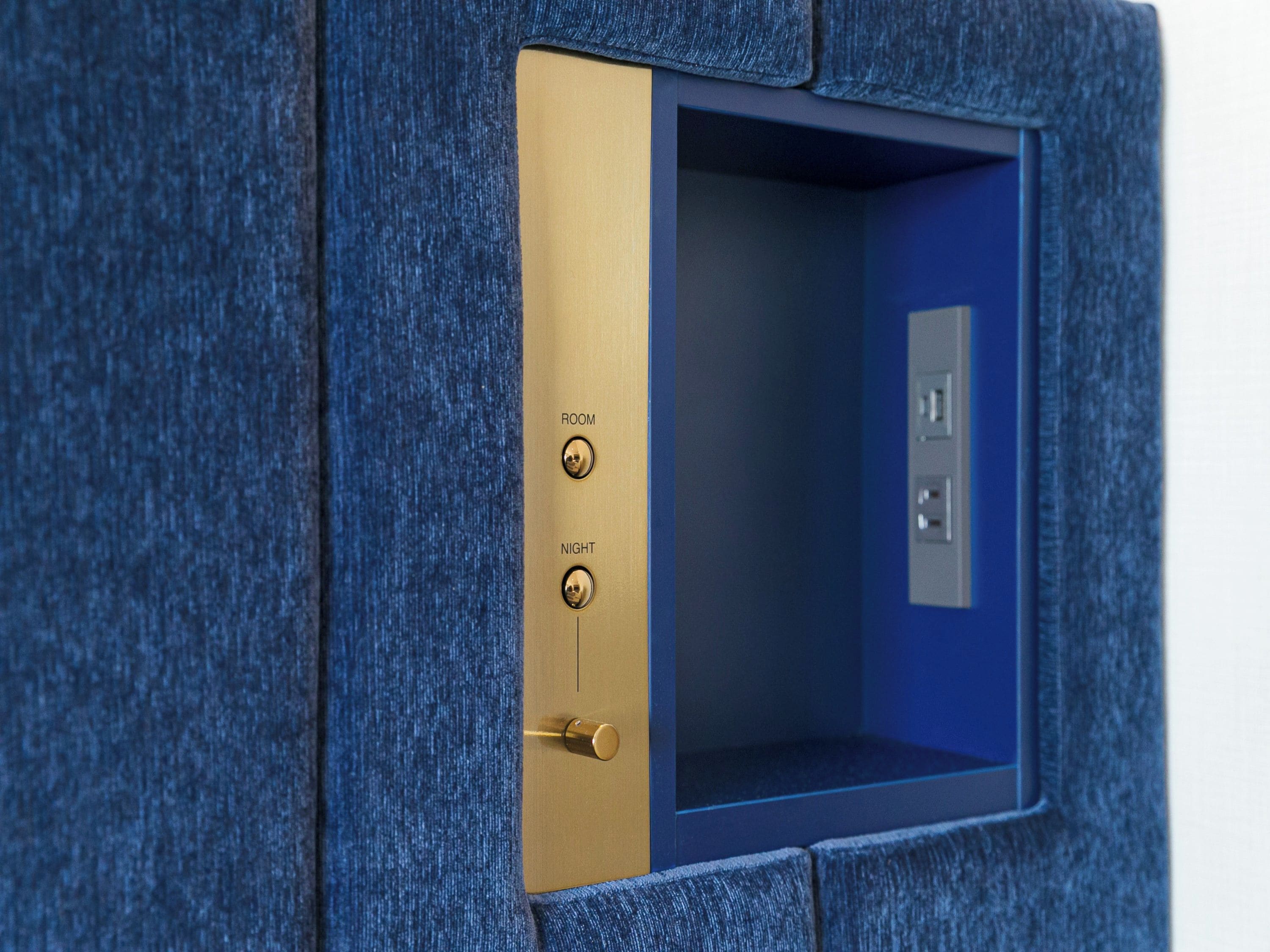 A blue textured wall with a brass door labeled 'ROOM' and 'NIGHT' indicating a room feature.