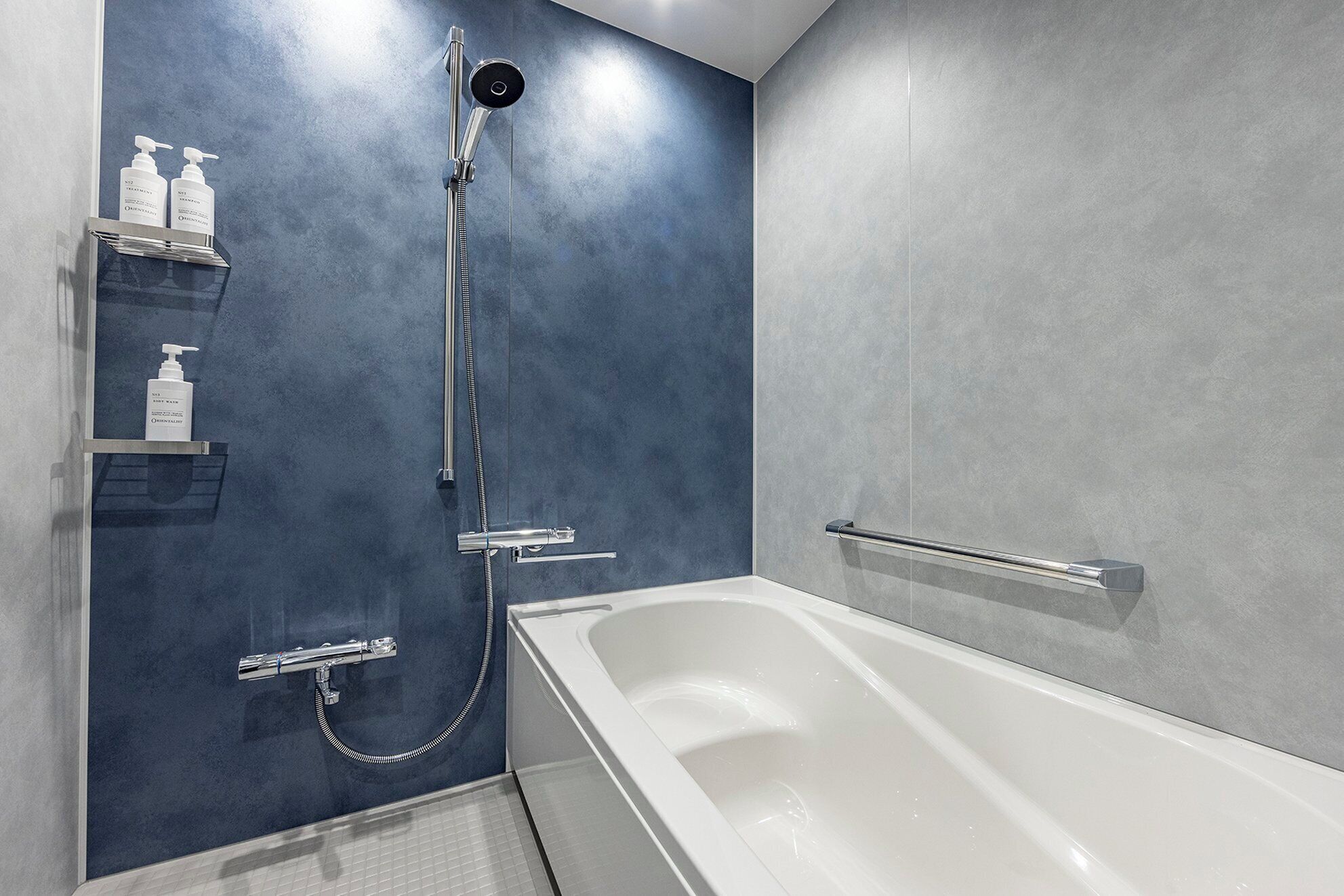 A modern bathroom with a bathtub, a shower, and a shelf with toiletries.