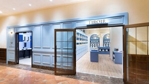 A Tiroir jewelry store with a blue facade, marble flooring, and glass display cases.