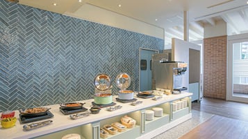Ein Buffet mit verschiedenen Speisen und Besteck, eine Wand mit Fischgrätmuster und eine Wand mit Ziegelakzenten.