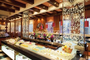 Uma área de buffet com diversas opções de comida e um painel decorativo.