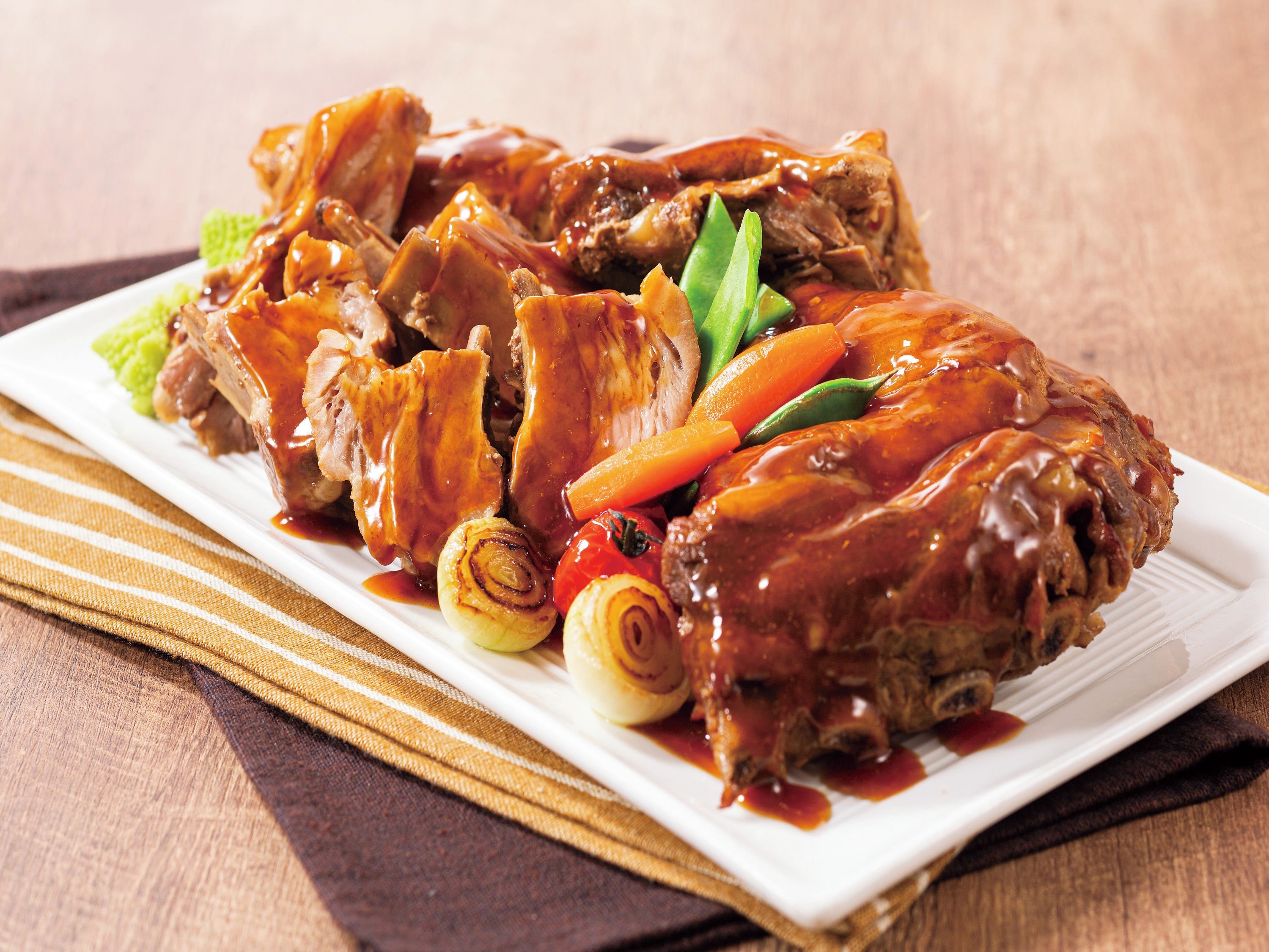 A plate of braised pork ribs with vegetables.