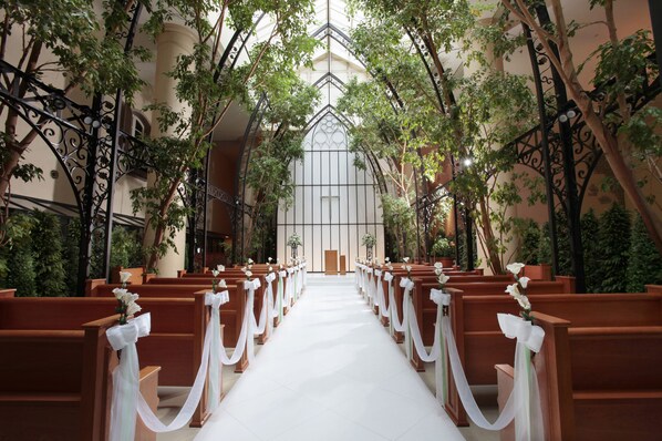 A church interior with pews arranged in rows, a central aisle, and a high ceiling with decorative ironwork. - Oriental Hotel Tokyo Bay (Urayasu)