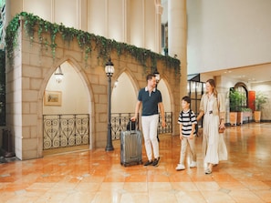A lobby with a tiled floor, a wall with greenery, and a black metal railing. - Oriental Hotel Tokyo Bay (Urayasu)