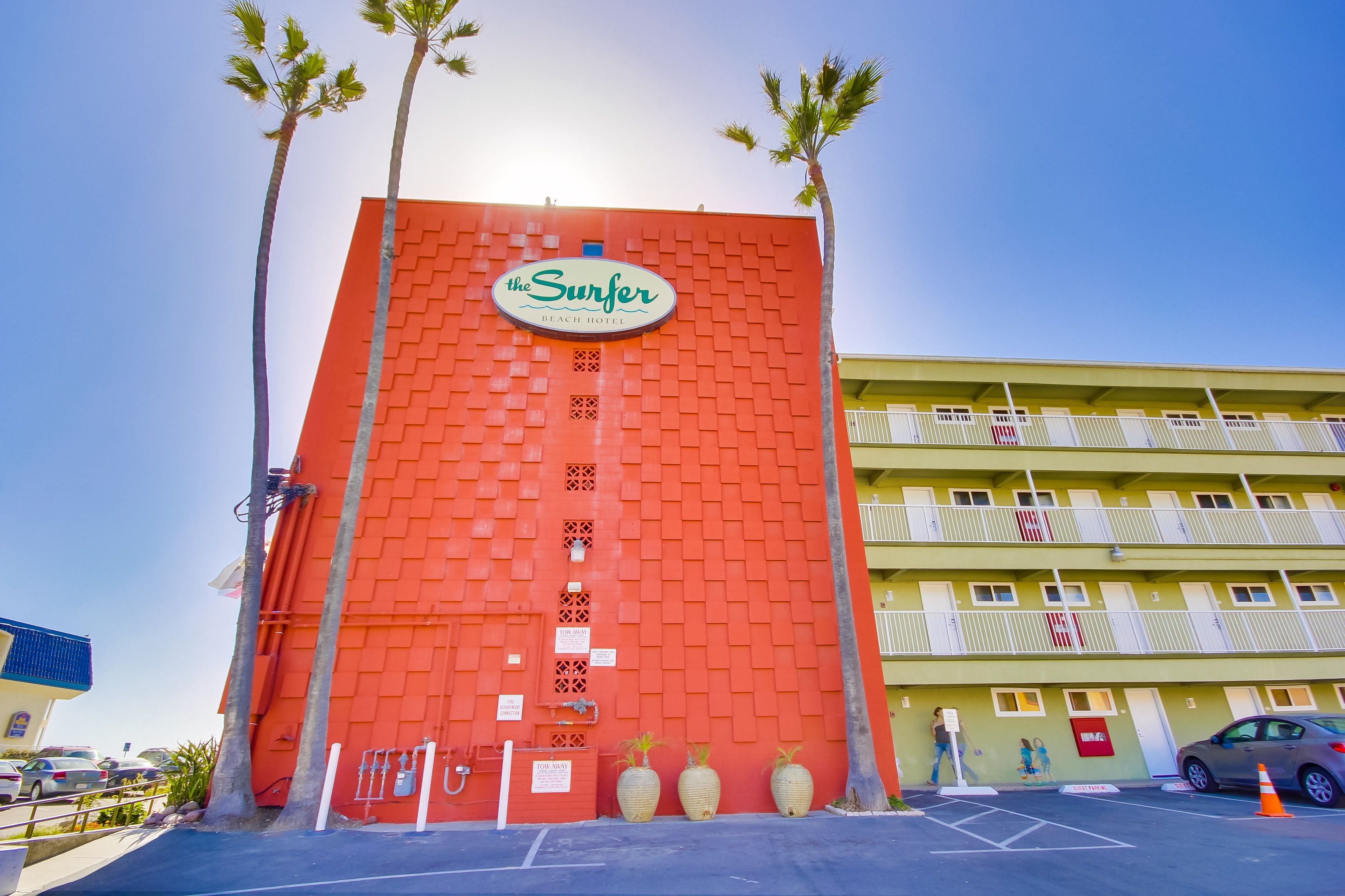 Un immeuble à la façade en briques rouges, sur lequel on peut lire l’inscription « The Surfer Beach Hotel ».