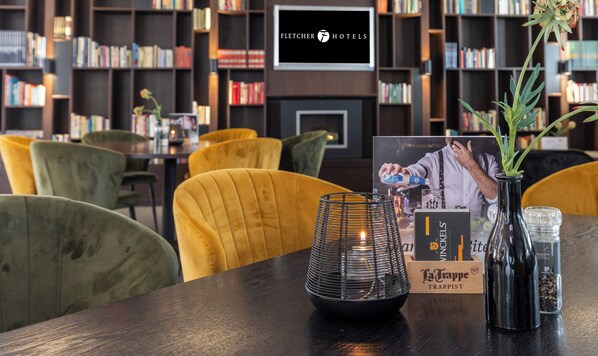 A hotel lobby with a bar area, bookshelves, and seating. - Fletcher Hotel - Restaurant Doorwerth - Arnhem (Doorwerth)