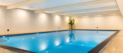 Una amplia piscina interior con paredes y suelo de baldosas.