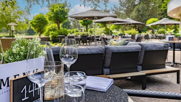 Un espace extérieur aménagé avec des tables, des chaises et des parasols.