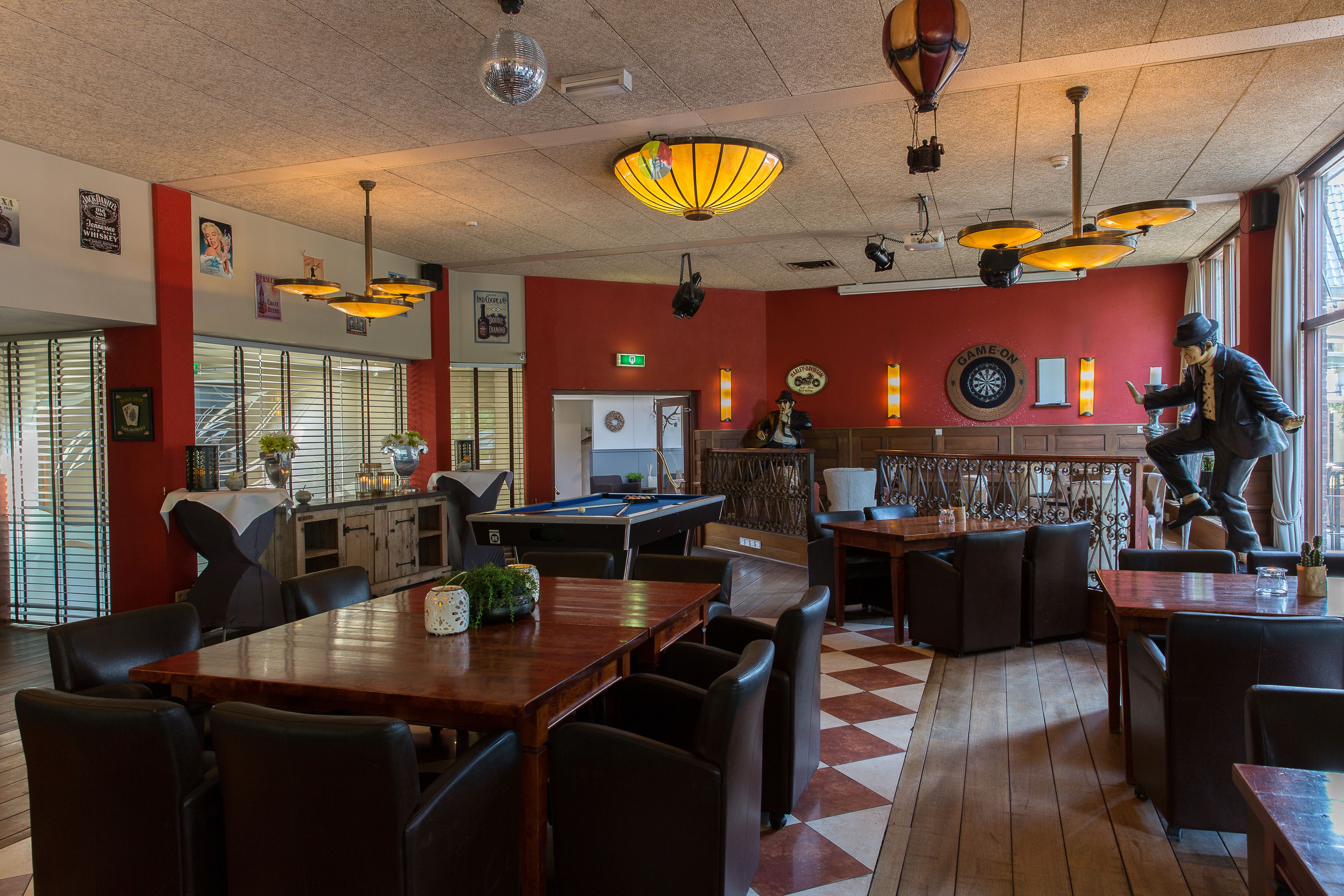 A billiards room with a pool table, seating area, and a dartboard.