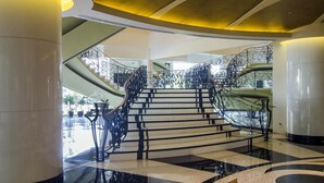 A grand staircase with ornate metal railings, leading to multiple levels. - The Bellevue Manila  (Muntinlupa)