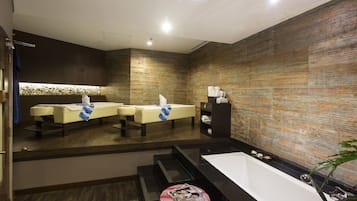 Relax in a spacious bathroom with a large bathtub, sink, and two massage chairs.