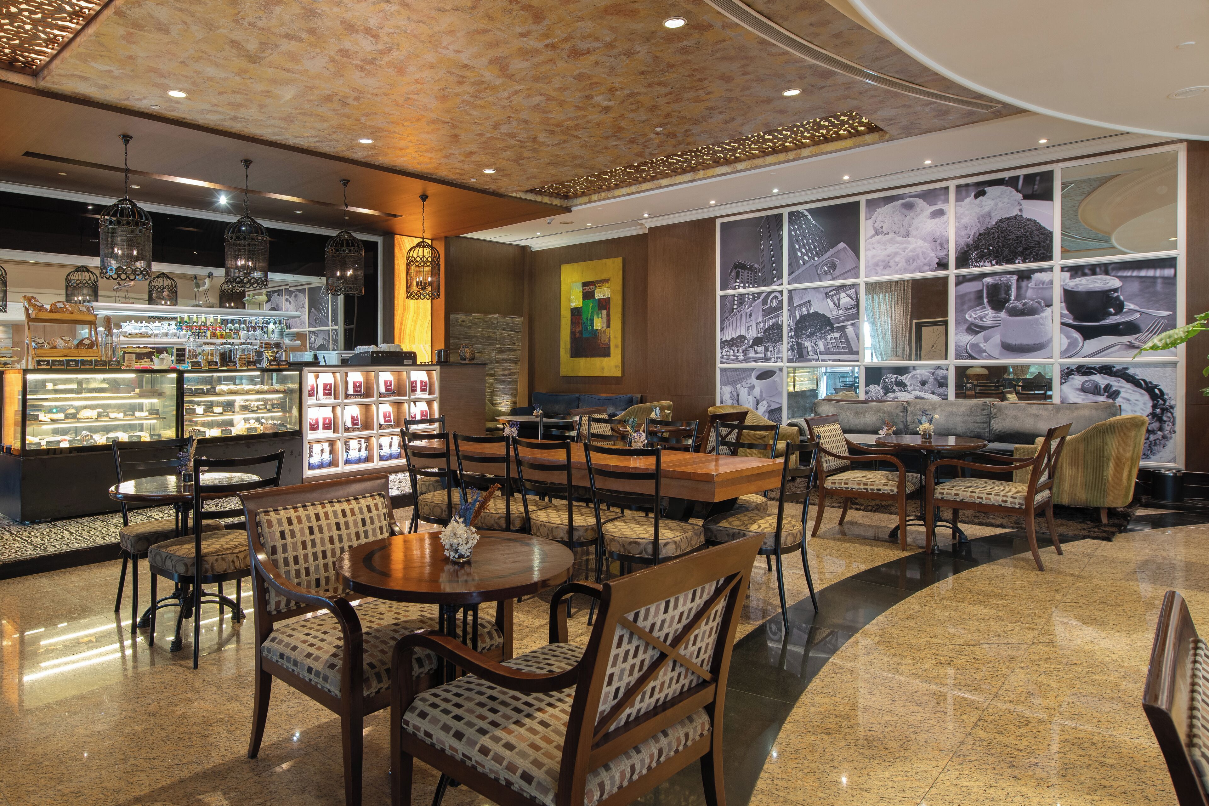 A spacious lobby with a coffee bar, seating area, and a large window displaying cityscape views.