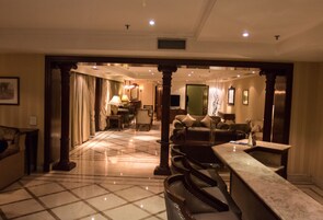 Eine geräumige Lobby mit Marmorboden, einem Empfangsbereich und einer Sitzecke mit Sofas.