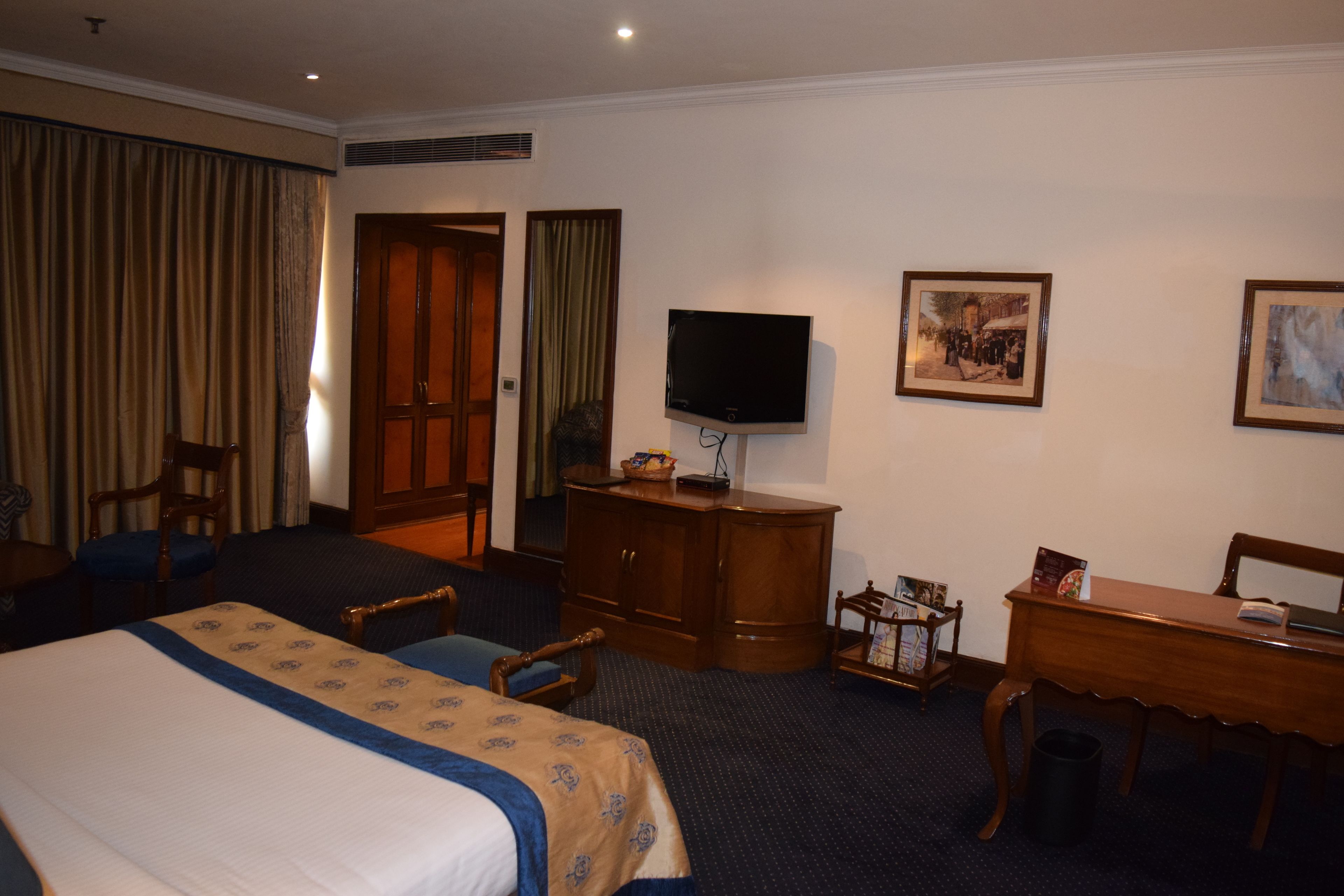 Une chambre d’hôtel équipée d’un lit, d’un bureau, d’une télévision et d’une chaise.