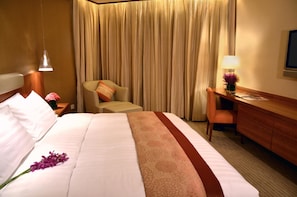 Relax in comfort with a neatly made bed and a desk for work or reading.