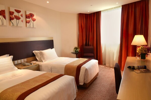 A hotel room with two beds, a desk, a chair, a lamp, and a window with curtains. - Grandview Hotel Macau (Taipa)
