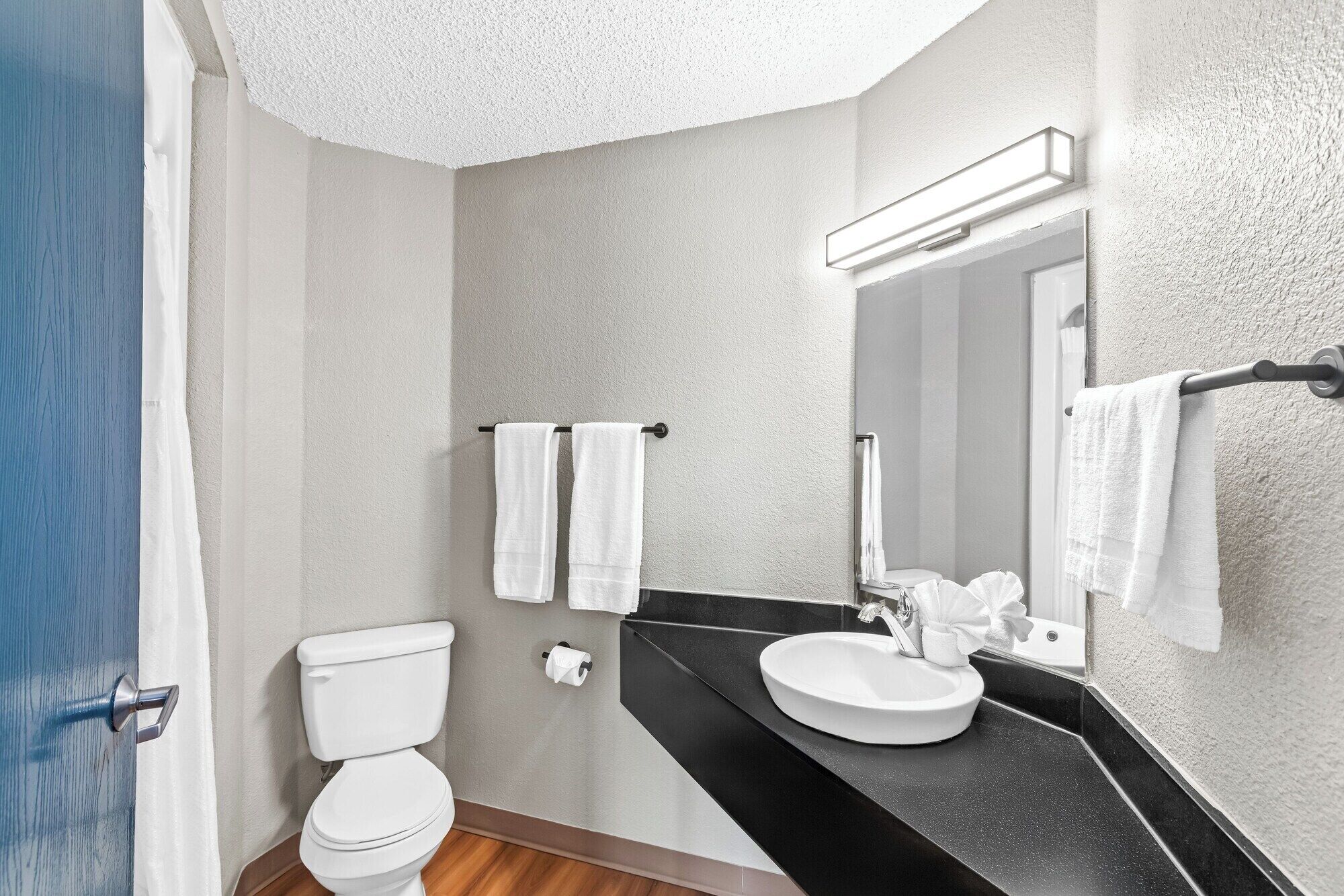 A modern bathroom with a toilet, sink, and towel rack.