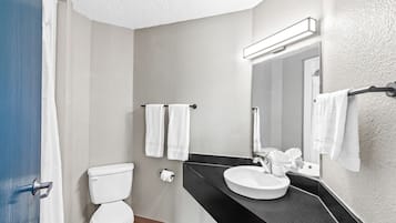 Un baño moderno con inodoro, lavamanos y toallero.