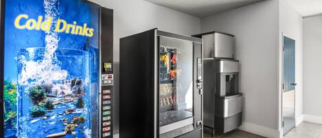 A hotel lobby with a cold drink vending machine, a refrigerator, and a microwave.