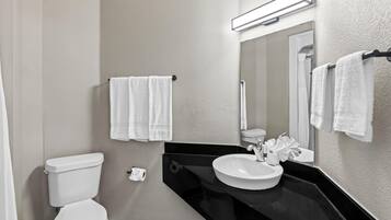 A modern bathroom with a toilet, sink, and mirror.