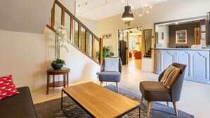 Un vestíbul modern amb una escala, zona de seients i una recepció.