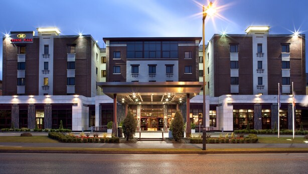 Een modern hotel met een overdekte ingang, meerdere verdiepingen en een bord waarop 