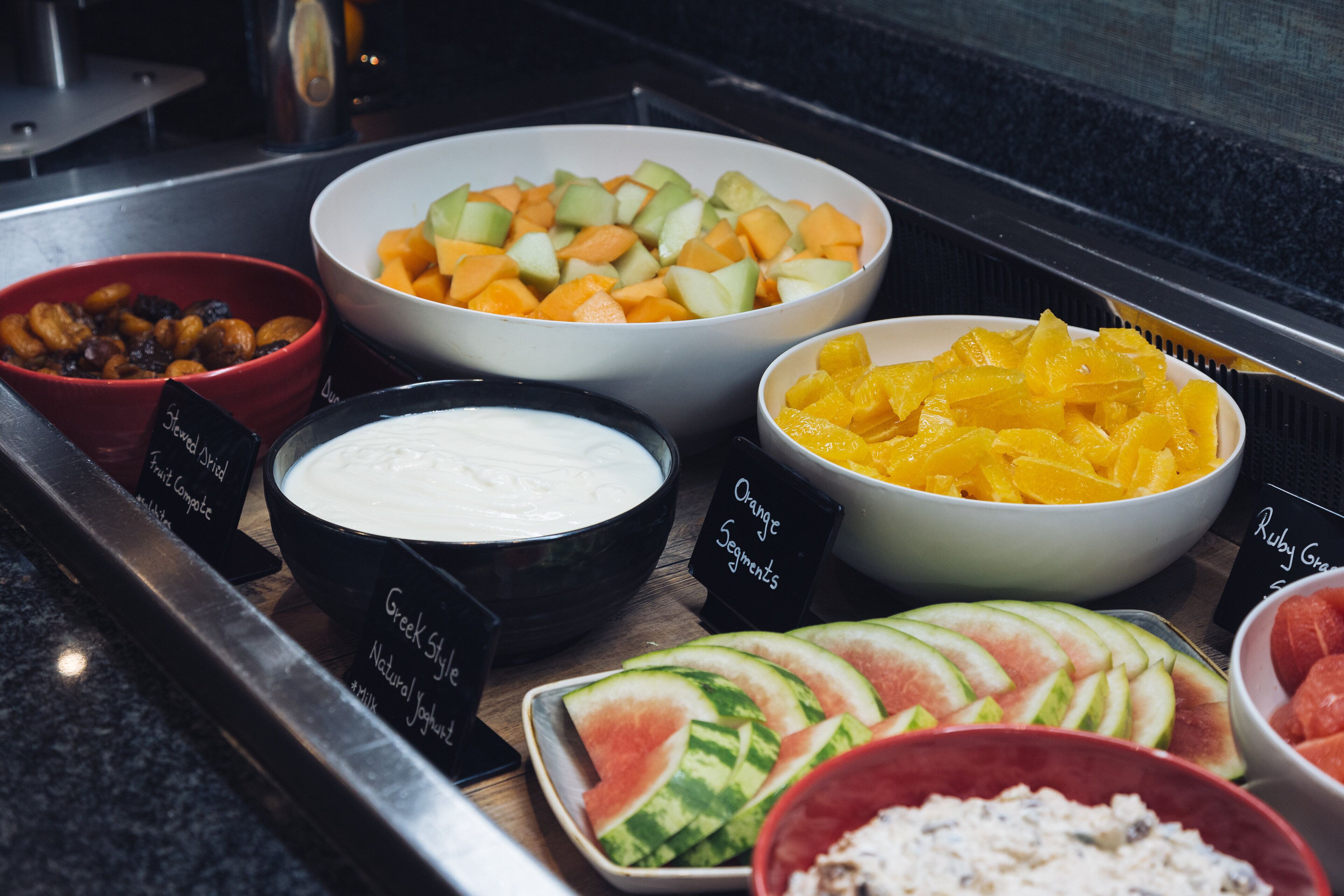 A buffet with various fruit and yogurt options.