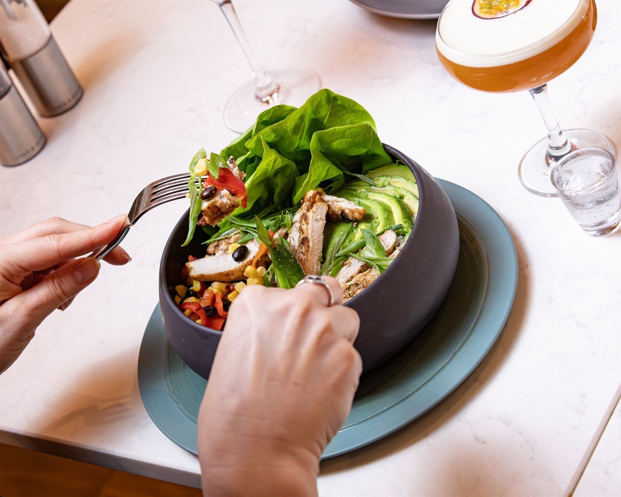 Una persona comiendo una ensalada con un tenedor.