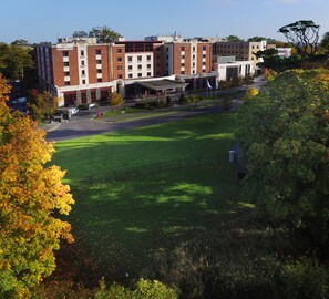 A building with multiple floors, a parking area, and a grassy courtyard.