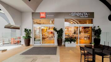 A modern interior with a restaurant named 'SPONTA PIZZA BAR' and a store named 'ibis São Paulo Paulista'.