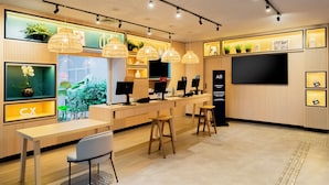 Een modern interieur met een receptiebalie, een bar, zitplaatsen en een televisiescherm.