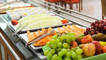 Um buffet com diversas frutas e queijos.