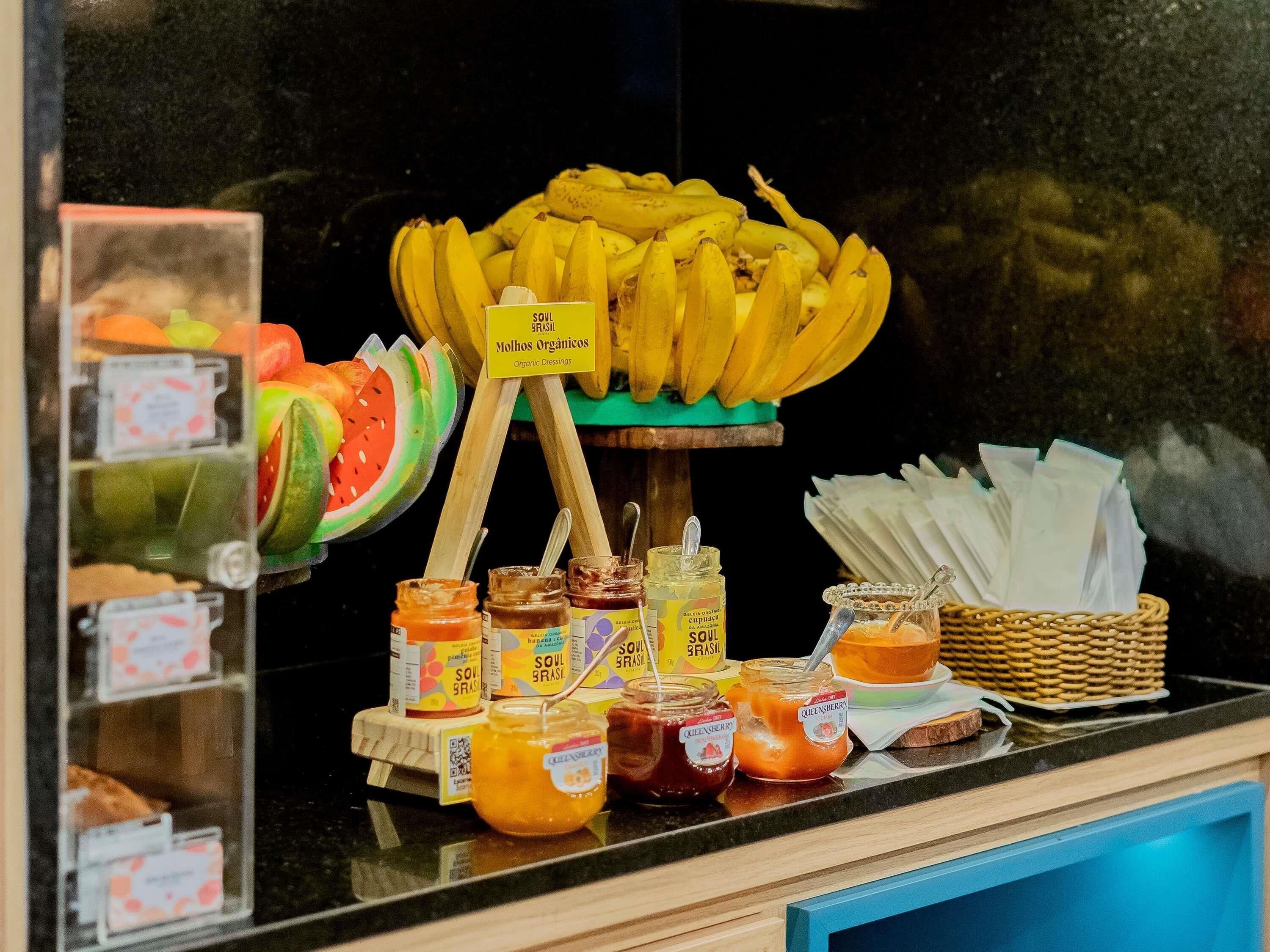 A display of bananas, organic dressings, and jars of jam.